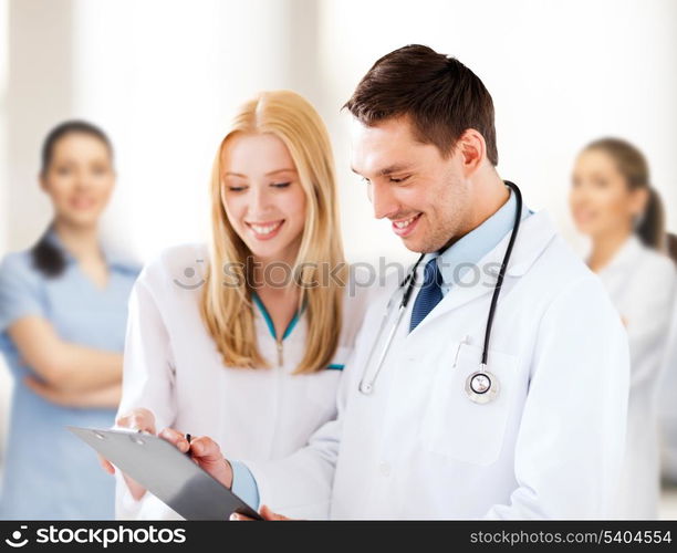 healthcare and medical concept - two doctors writing prescription