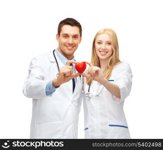 healthcare and medical concept - two young doctors cardiologists with heart