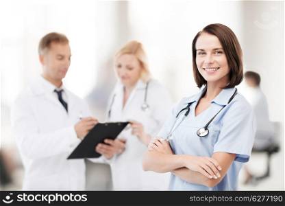 healthcare and medical concept - young female doctor with colleagues in hospital