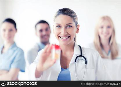 healthcare and medical concept - young female doctor with jar of capsules. female doctor with jar of capsules