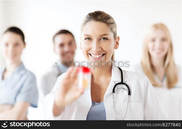 healthcare and medical concept - young female doctor with jar of capsules