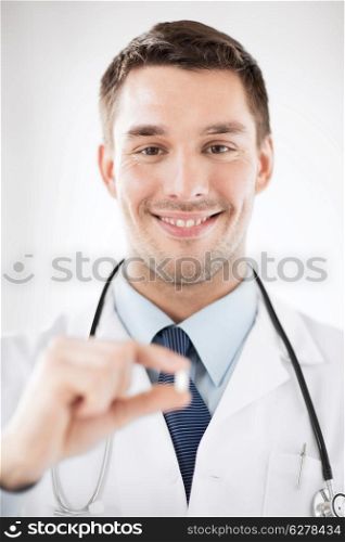 healthcare and medical concept - young male doctor offering pill