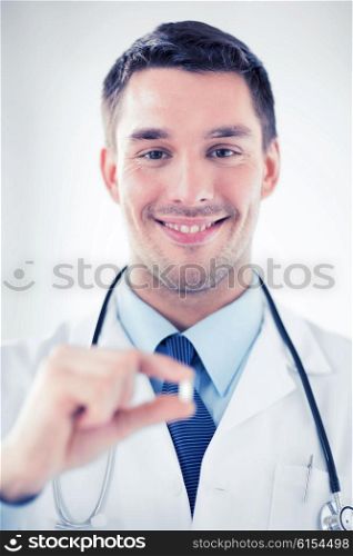 healthcare and medical concept - young male doctor offering pill. young male doctor offering pill