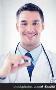 healthcare and medical concept - young male doctor offering pill. young male doctor offering pill