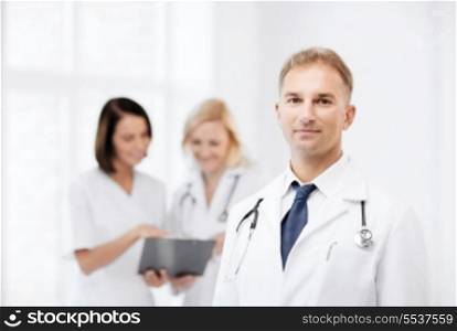 healthcare and medical concept - young male doctor with colleagues in hospital