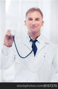 healthcare and medical concept - young male doctor with stethoscope. young male doctor with stethoscope