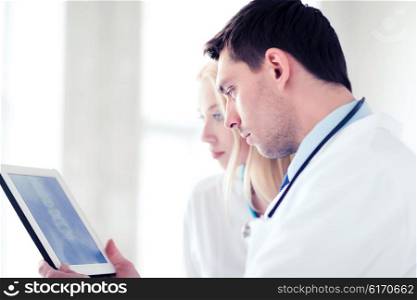 healthcare and medical - two doctors looking at x-ray on tablet pc. two doctors looking at x-ray on tablet pc