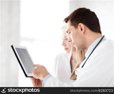 healthcare and medical - two doctors looking at x-ray on tablet pc