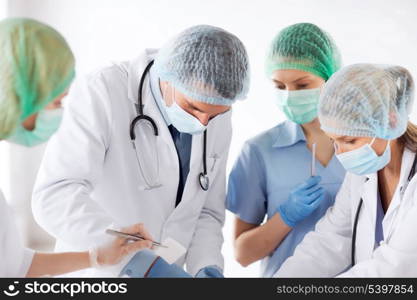 healthcare and medical - young group of doctors doing operation