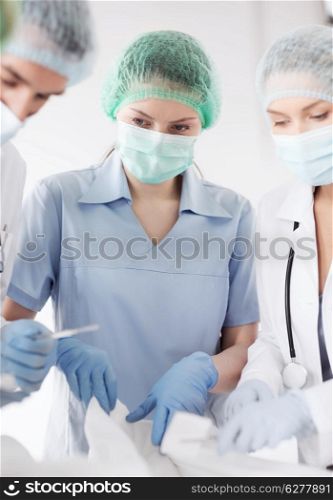 healthcare and medical - young group of doctors doing operation