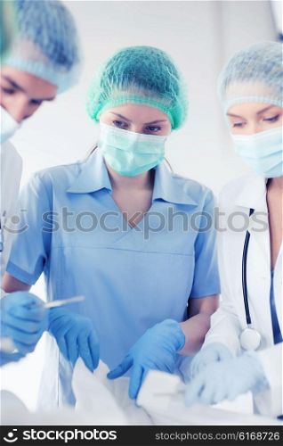 healthcare and medical - young group of doctors doing operation. young group of doctors doing operation