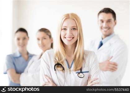 healthcare and medicine concept - attractive female doctor in front of medical group