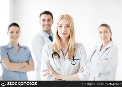 healthcare and medicine concept - attractive female doctor in front of medical group