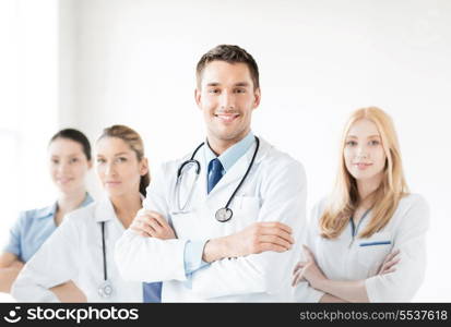 healthcare and medicine concept - attractive male doctor in front of medical group