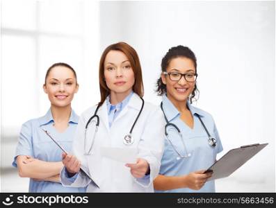 healthcare and medicine concept - calm female doctor and nurses with clipboard and stethoscope giving prescription