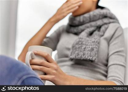 healthcare and medicine concept - close up of ill woman drinking tea at home. close up of ill woman drinking tea at home