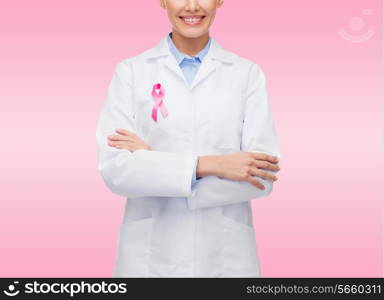healthcare and medicine concept - close up of smiling female doctor with pink cancer awareness ribbon over pink background