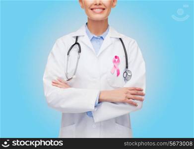healthcare and medicine concept - close up of smiling female doctor with stethoscope and pink cancer awareness ribbon over blue background