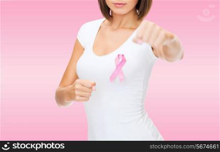 healthcare and medicine concept - close up smiling young woman in blank white t-shirt with pink breast cancer awareness ribbon fighting over pink background