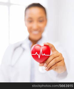 healthcare and medicine concept - female african american doctor holding red heart with ecg line