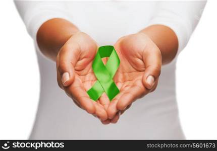 healthcare and medicine concept - female hands holding green organ transplant awareness ribbon