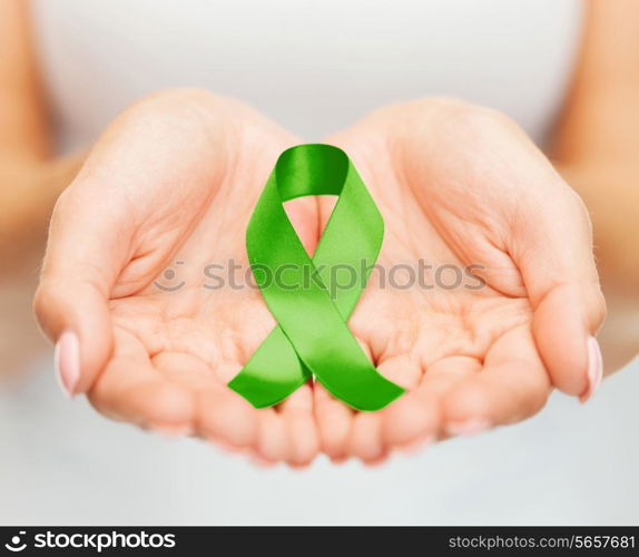 healthcare and medicine concept - female hands holding green organ transplant awareness ribbon