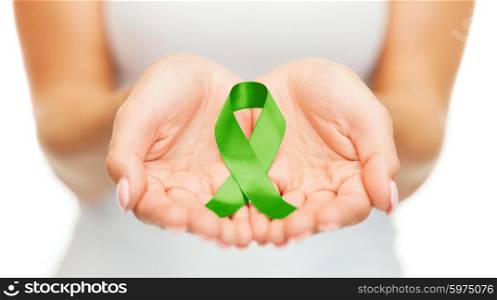 healthcare and medicine concept - female hands holding green organ transplant awareness ribbon. hands holding green awareness ribbon