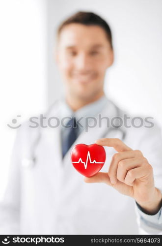 healthcare and medicine concept - male doctor holding red heart with ecg line