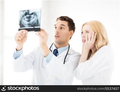 healthcare and medicine concept - picture of two doctors looking at x-ray