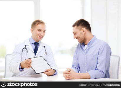 healthcare and medicine concept - smiling doctor with clipboard and patient in hospital