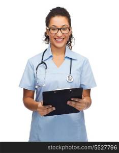 healthcare and medicine concept - smiling female african american doctor or nurse in eyeglasses with stethoscope and clipboard