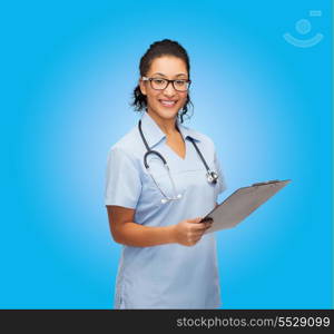 healthcare and medicine concept - smiling female african american doctor or nurse in eyeglasses with stethoscope and clipboard