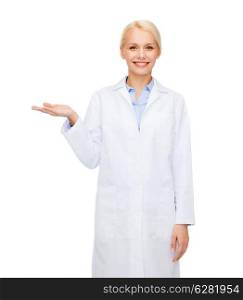 healthcare and medicine concept - smiling female doctor holding something on palm of her hand