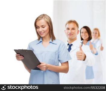 healthcare and medicine concept - smiling female doctor or nurse with clipboard