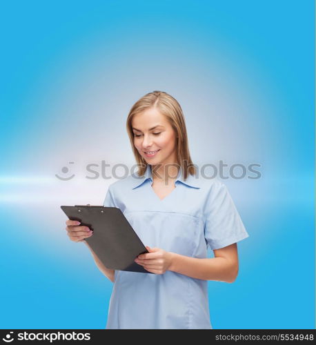 healthcare and medicine concept - smiling female doctor or nurse with clipboard