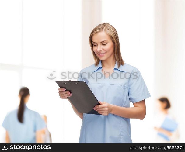 healthcare and medicine concept - smiling female doctor or nurse with clipboard