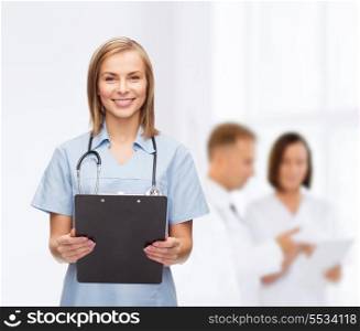 healthcare and medicine concept - smiling female doctor or nurse with clipboard and stethoscope