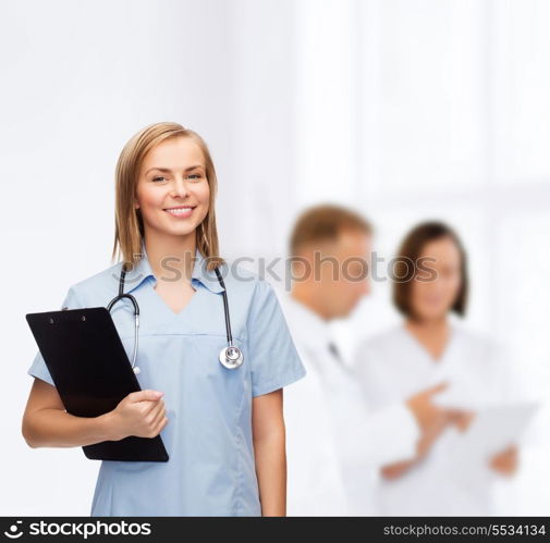 healthcare and medicine concept - smiling female doctor or nurse with clipboard and stethoscope