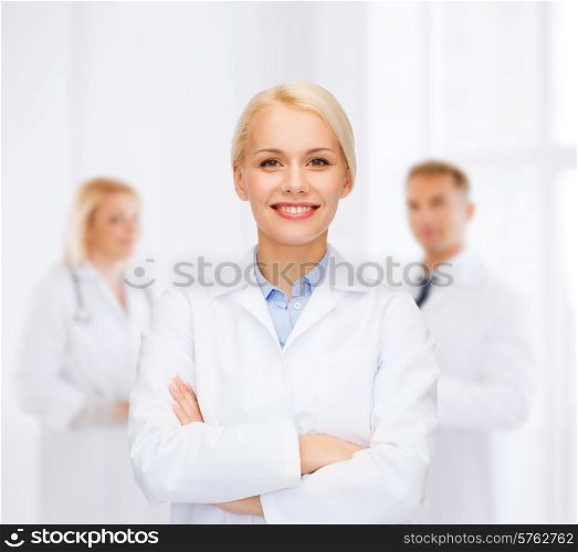 healthcare and medicine concept - smiling female doctor over group of medics in hospital