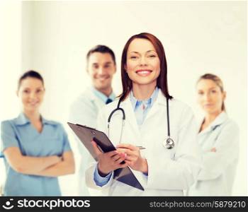 healthcare and medicine concept - smiling female doctor with clipboard and stethoscope. smiling female doctor with clipboard
