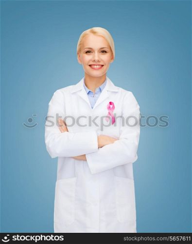healthcare and medicine concept - smiling female doctor with pink cancer awareness ribbon over blue background