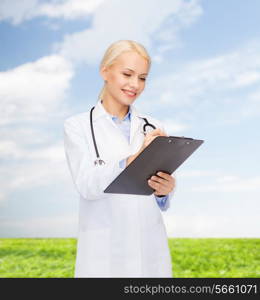 healthcare and medicine concept - smiling female doctor with stethoscope and clipboard