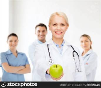 healthcare and medicine concept - smiling female doctor with stethoscope and green apple
