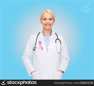 healthcare and medicine concept - smiling female doctor with stethoscope and pink cancer awareness ribbon over blue background