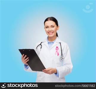 healthcare and medicine concept - smiling female doctor with stethoscope, clipboard and pink cancer awareness ribbon over blue background