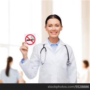 healthcare and medicine concept - smiling female doctor with stethoscope holding no smoking sign