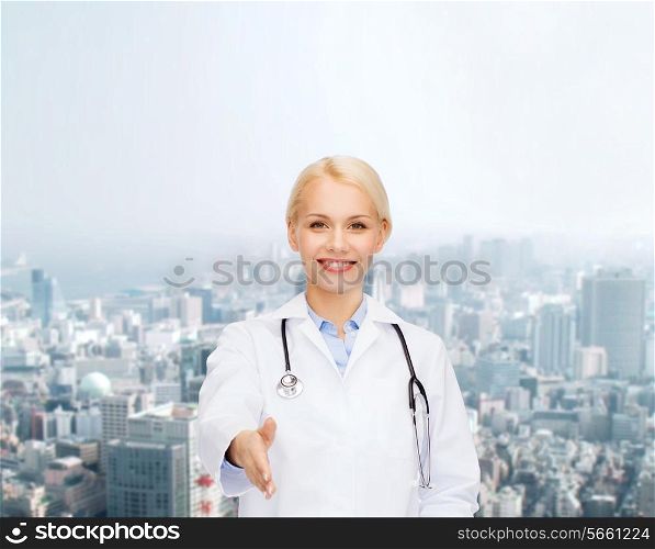 healthcare and medicine concept - smiling female doctor with stethoscope ready to shake hands