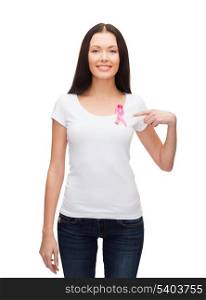 healthcare and medicine concept - smiling woman in blank t-shirt with pink breast cancer awareness ribbon
