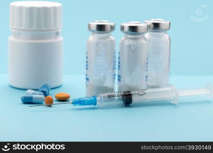 Healthcare and medicine concept.Syringe, pills and medicine bottle on blue background