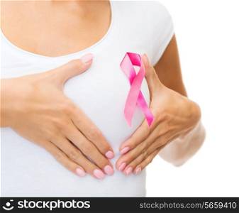 healthcare and medicine concept - woman in blank t-shirt with pink breast cancer awareness ribbon checking breast